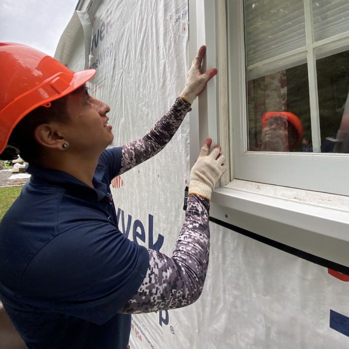 Golden Group Roofing contractor working on installing vinyl siding