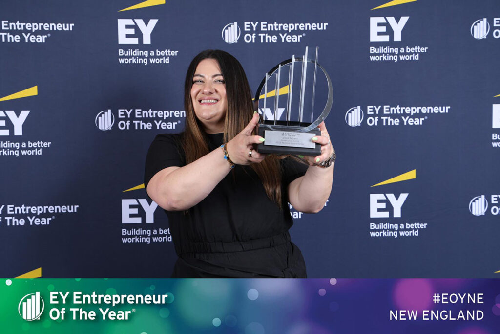 Greta Bajrami, Golden Group Roofing's founder, holds the Entrepreneur of the Year 2023 award up.