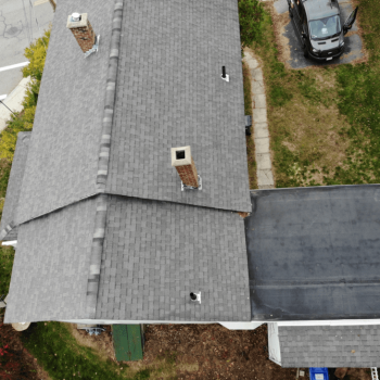Aerial view of a small residential home with a slanted shingled roof completed by The Golden Group.